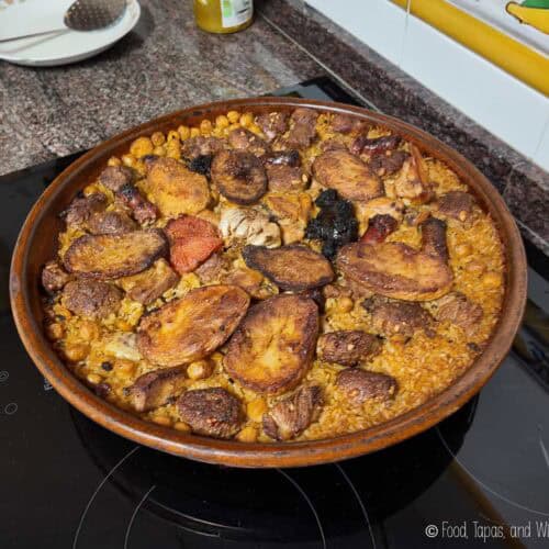 Traditional arroz al horno baked in a clay dish with pork, potatoes, chickpeas, and garlic